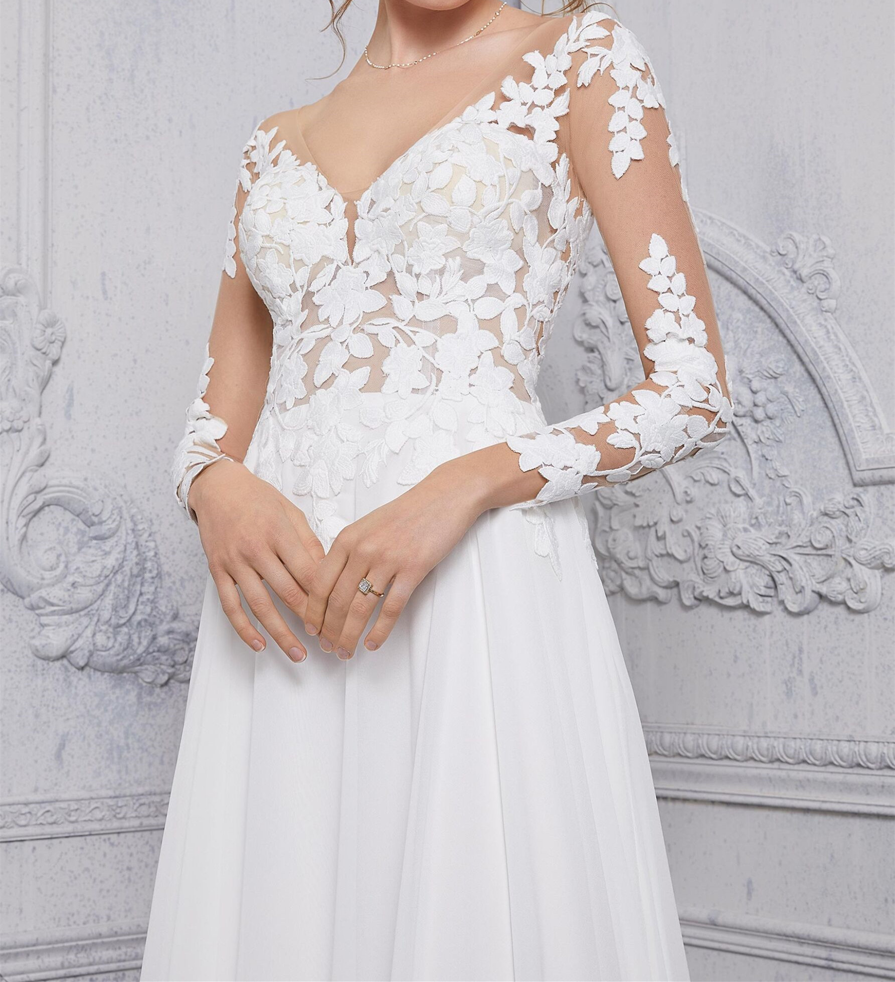 The long sleeve net bodice, with v-neckline, meets up with an A-line chiffon skirt