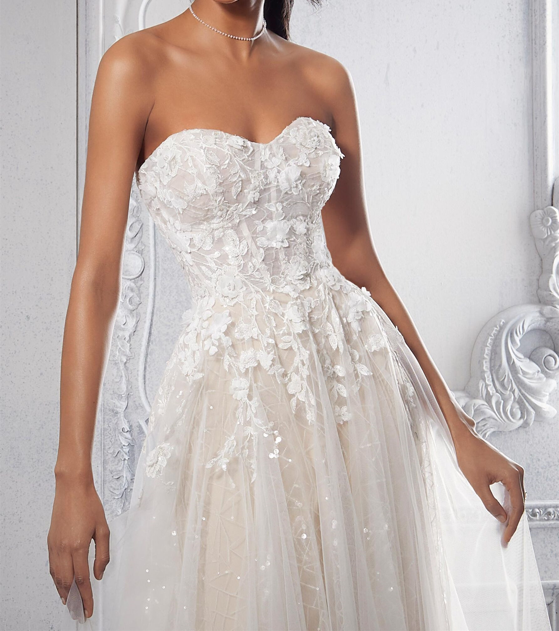 This net A-line wedding dress features a strapless bodice with a sweetheart neckline