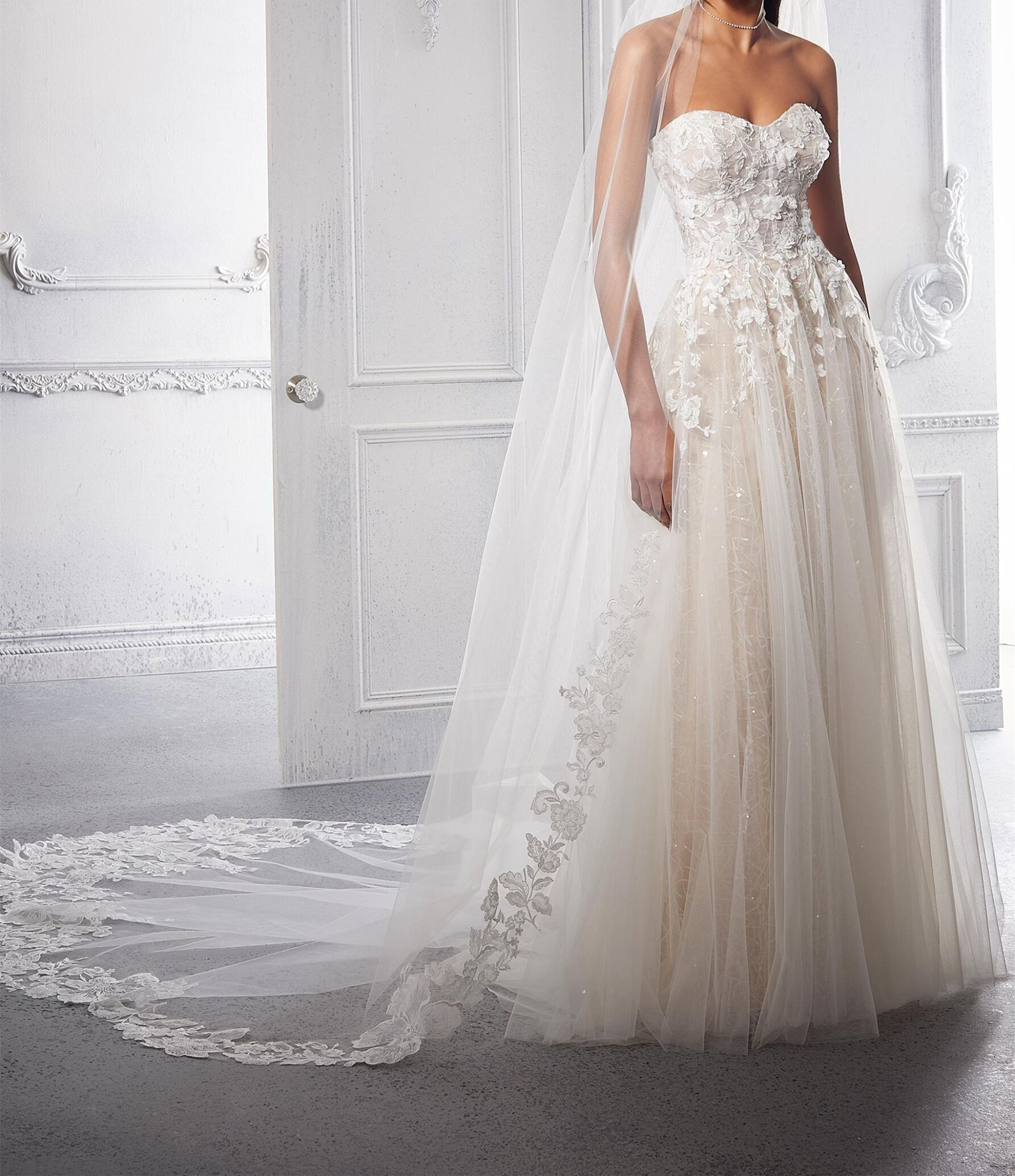 This net A-line wedding dress features a strapless bodice with a sweetheart neckline